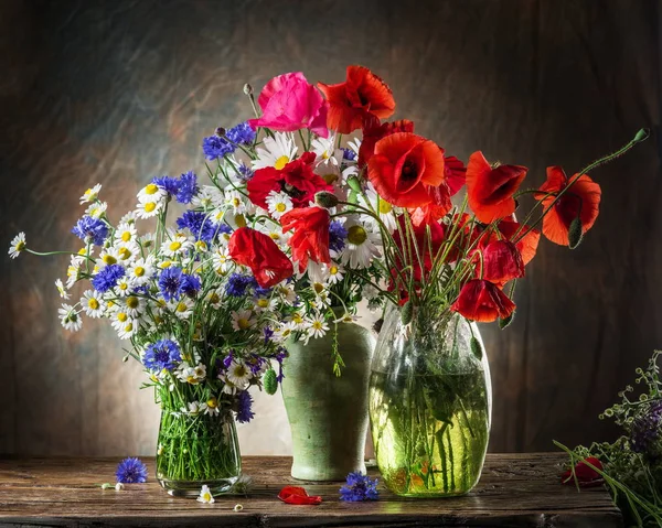 Ramo de flores de campo en el jarrón de la mesa de madera . — Foto de Stock