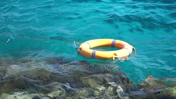 Bouée de sauvetage orange sur une mer bleue. Mouvement lent . — Video