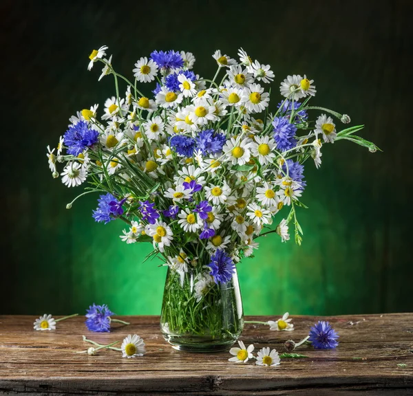 Buquê de camomilas e flores de milho no vaso na madeira — Fotografia de Stock