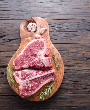 Ahşap kesme tahtası üzerinde baharatlar ile T-bone biftek.