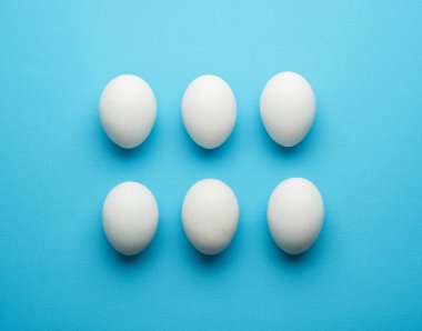 Mavi zemin üzerine beyaz tavuk yumurtası.