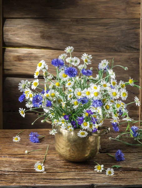 Boeket van chamomiles en korenbloemen in de vaas op de houten — Stockfoto