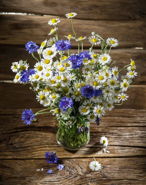 Bouquet de camomilles et de bleuets dans le vase sur le bois — Photo