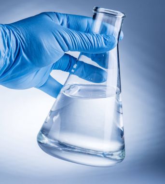 Laboratuvar kabı plastik eldiven analist'ın elinde.
