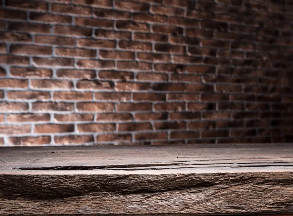Antigua mesa vacía de madera y pared de ladrillo en el fondo . — Foto de Stock