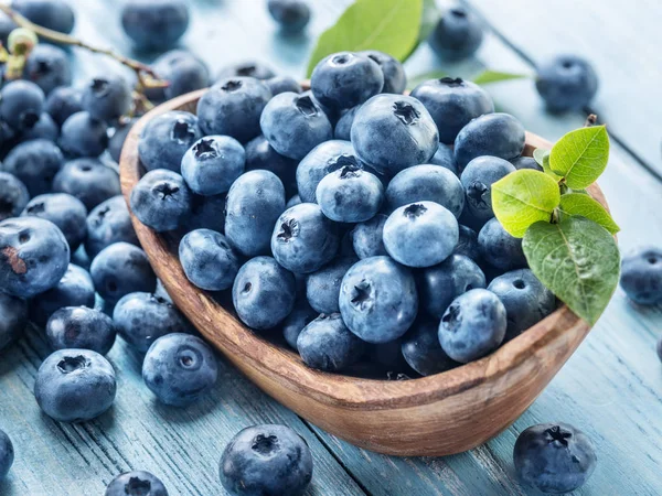 Blaubeeren in der Holzschale auf dem Tisch. — Stockfoto