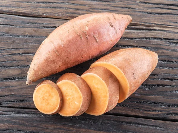 Batatas doces na velha mesa de madeira. — Fotografia de Stock