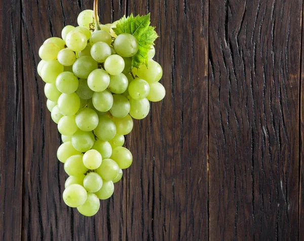 Beyaz üzüm demet. Eski ahşap arka plan üzerine.