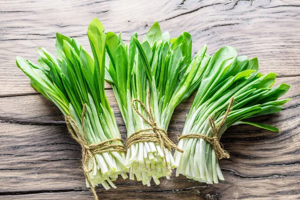 Ahşap masa üzerinde genç taze yabani sarımsak.
