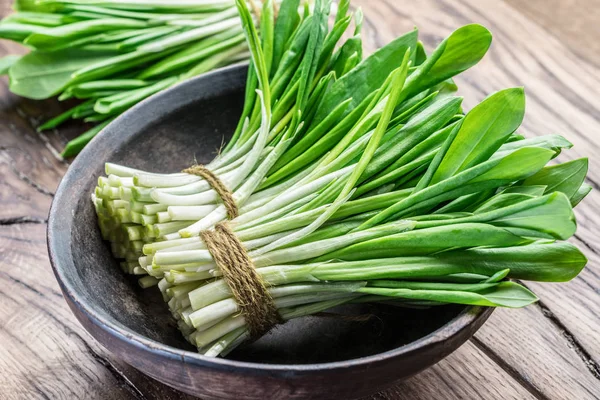 Ahşap masa üzerinde genç taze yabani sarımsak.
