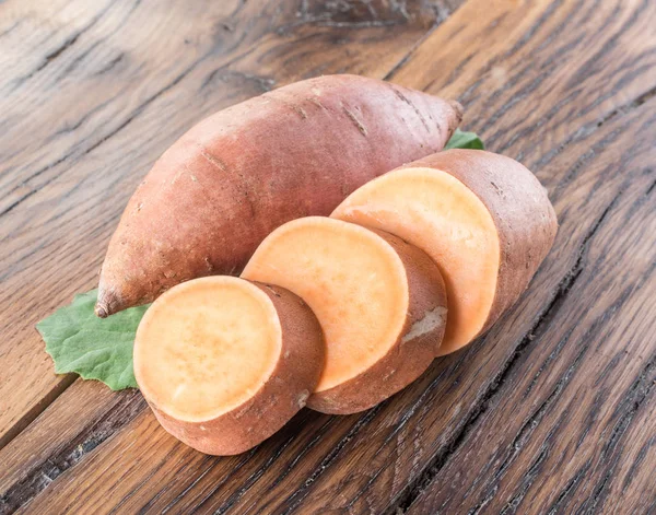 Batatas doces na velha mesa de madeira. — Fotografia de Stock