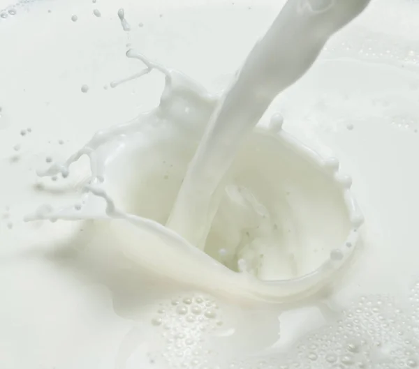 Hälla mjölk och mjölk splash. Närbild. — Stockfoto