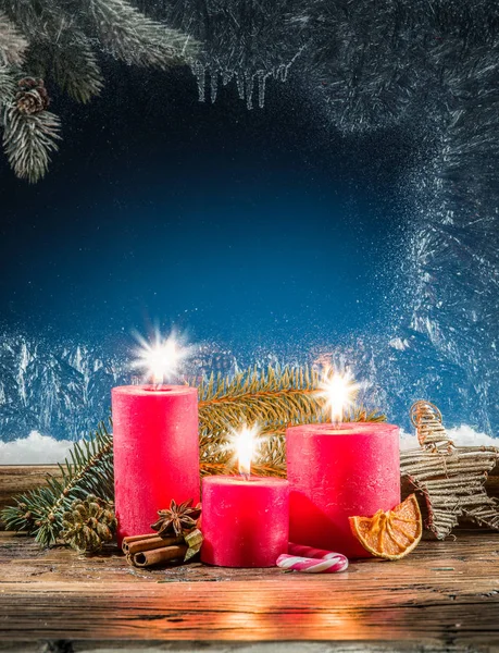 Candle lights and frozen window. Christmas background. — Stock Photo, Image