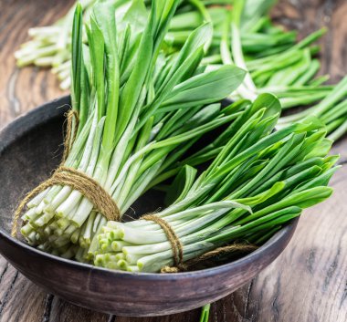 Ahşap masa üzerinde genç taze yabani sarımsak.