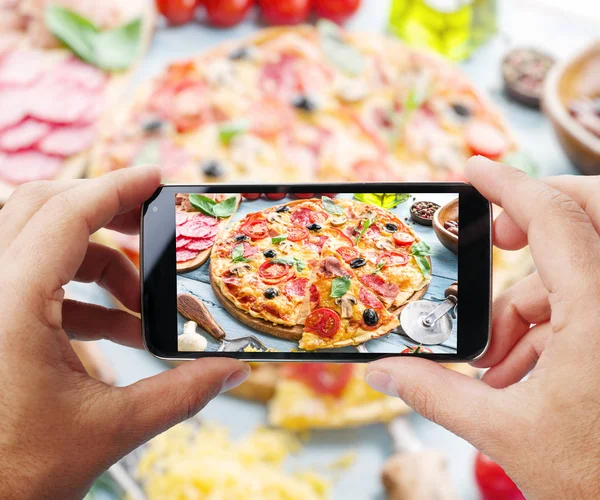 Taking photo of pizza by smartphone.