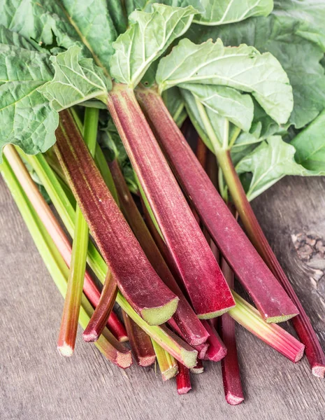 Tiges de rhubarbe comestibles sur la table en bois . — Photo