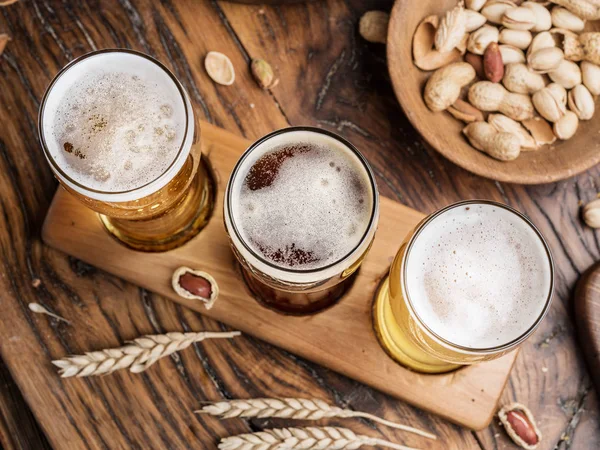 Vasos de cerveza y aperitivos en la mesa de madera . —  Fotos de Stock