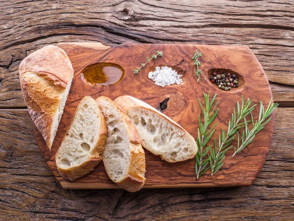 Potongan ciabatta dengan tanaman rosemary pada nampan kayu yang disajikan — Stok Foto