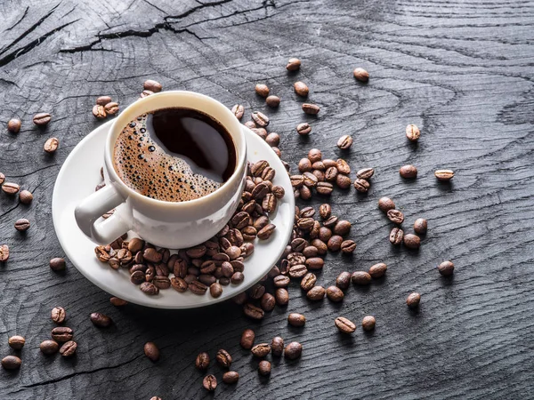 Kopp kaffe omgiven av kaffebönor. Ovanifrån. — Stockfoto