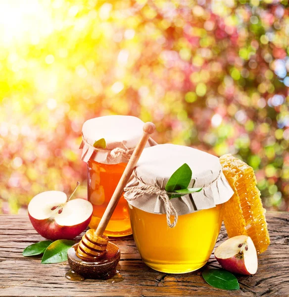 Gläser mit frischem Honig und Waben auf dem Holztisch. — Stockfoto