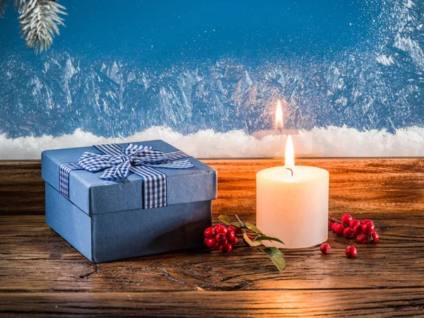 Gift boxes, candle lights and frozen window. Christmas backgroun