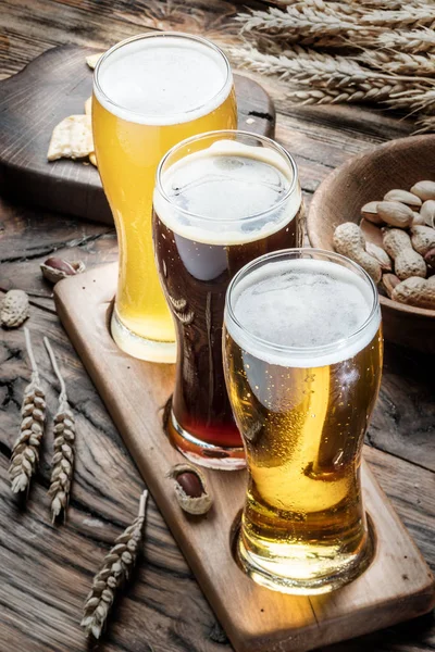 Glasses of beer and snacks on the wooden table. — Stock Photo, Image