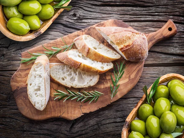 Fette di ciabatta con olive e spezie sulla porzione in legno — Foto Stock