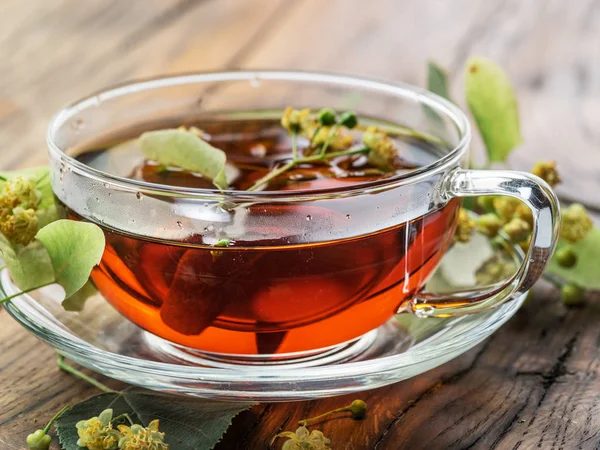 Secangkir teh linden dan bunga kapur di meja kayu . — Stok Foto