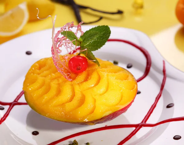 Dessert à la mangue décoré avec feuille de menthe et décoration au caramel . — Photo