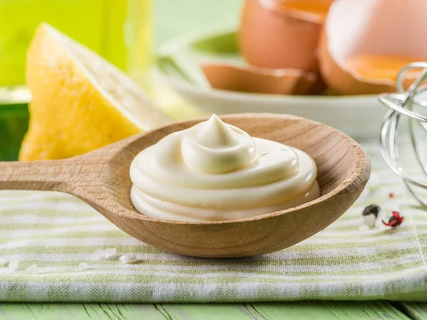 Natural mayonnaise sauce in the wooden spoon and its ingredient — Stock Photo, Image