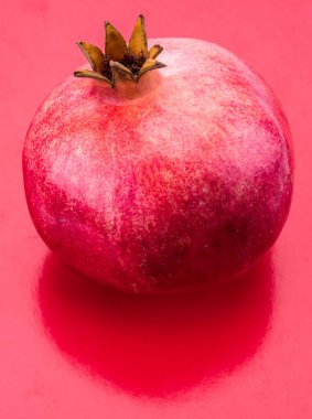 Olgun nar meyve kırmızı zemin üzerine.