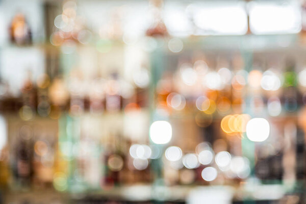 Colorful bottles on the bar shelves. Blurred background.