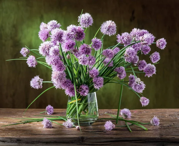 Ramo de cebolla (cebollino) flores en el jarrón en la mesa de madera — Foto de Stock