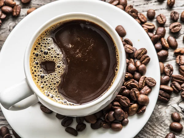 Una taza de café rodeada de granos de café. Vista superior . — Foto de Stock