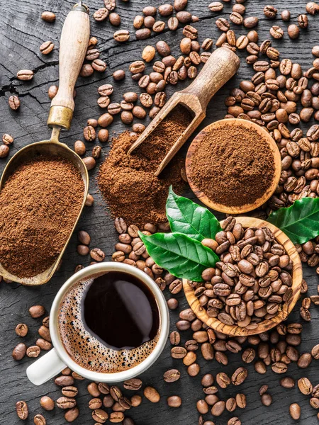 Palone ziarna kawy, zmielonej kawy i filiżanki kawy na drewniane — Zdjęcie stockowe