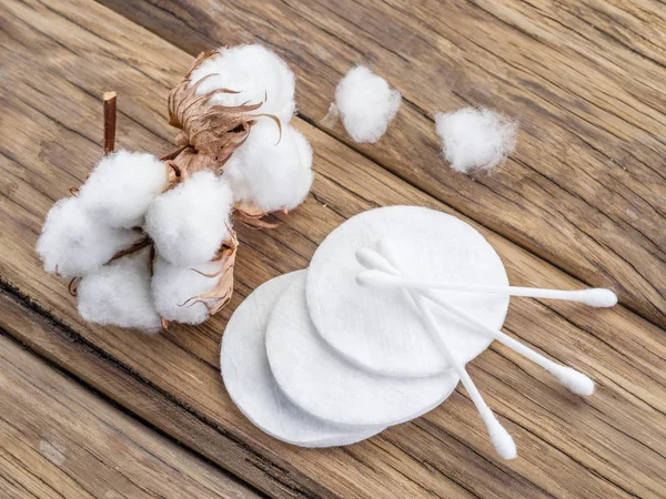 Fluffy cotton ball and cotton swabs and pads on wooden table. — Stock Photo, Image