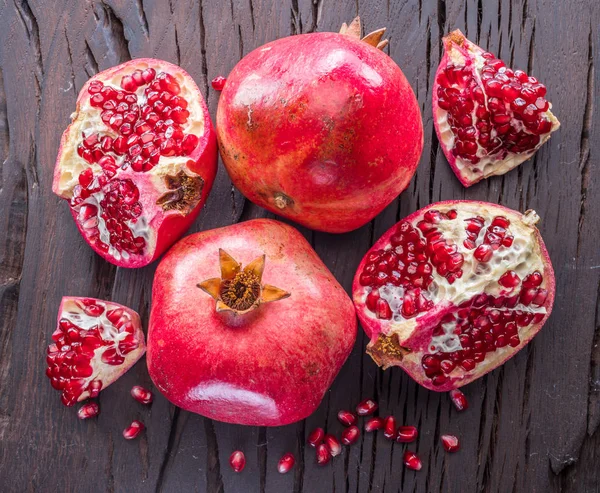 Ahşap zemin üzerinde olgun nar meyveleri.