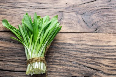 Ahşap masa üzerinde genç taze yabani sarımsak.