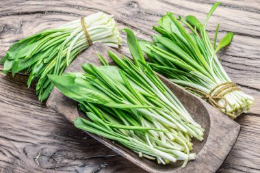 Ahşap masa üzerinde genç taze yabani sarımsak.