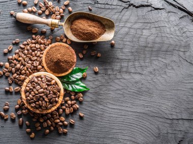 Kavrulmuş kahve çekirdekleri ve ahşap masa üzerinde çekilmiş kahve. Top vie