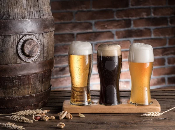 Vasos de cerveza y barril de cerveza en la mesa de madera. Cervecero artesanal —  Fotos de Stock