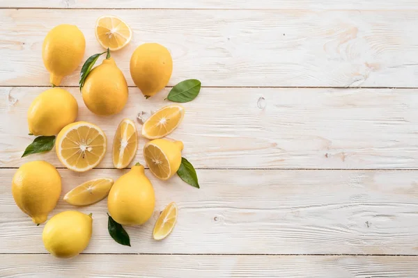 Спелые лимоны и лимонные листья на деревянном фоне. Вид сверху . — стоковое фото