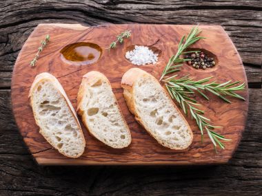 Dilim ciabatta biberiye bitki hizmet ahşap tepsi ile