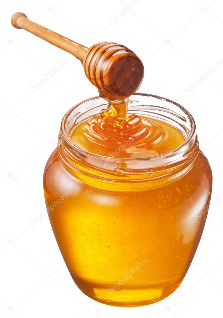 Jar full of fresh honey and honey dipper. File contains clipping