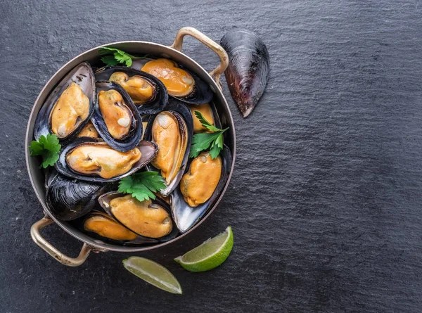 Mejillones en bandeja de cobre sobre fondo de grafito . — Foto de Stock