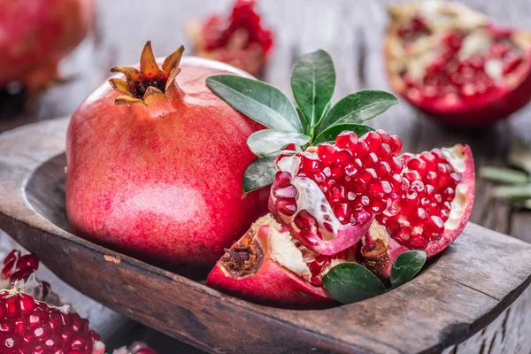 Frutas de romã maduras no fundo de madeira. — Fotografia de Stock