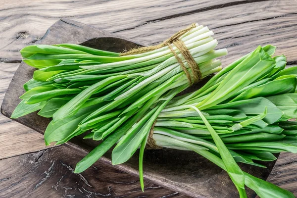 Young fresh wild garlic on the wooden table. — Stock Photo, Image