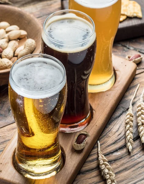 Glasögon av öl och snacks på tabellen trä. — Stockfoto