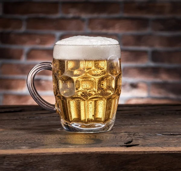 Frostad mugg öl på tabellen trä. — Stockfoto