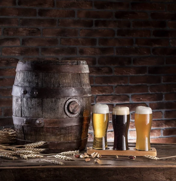 Ahşap masa üzerinde varil bira ve bira gözlük. Zanaat bira — Stok fotoğraf